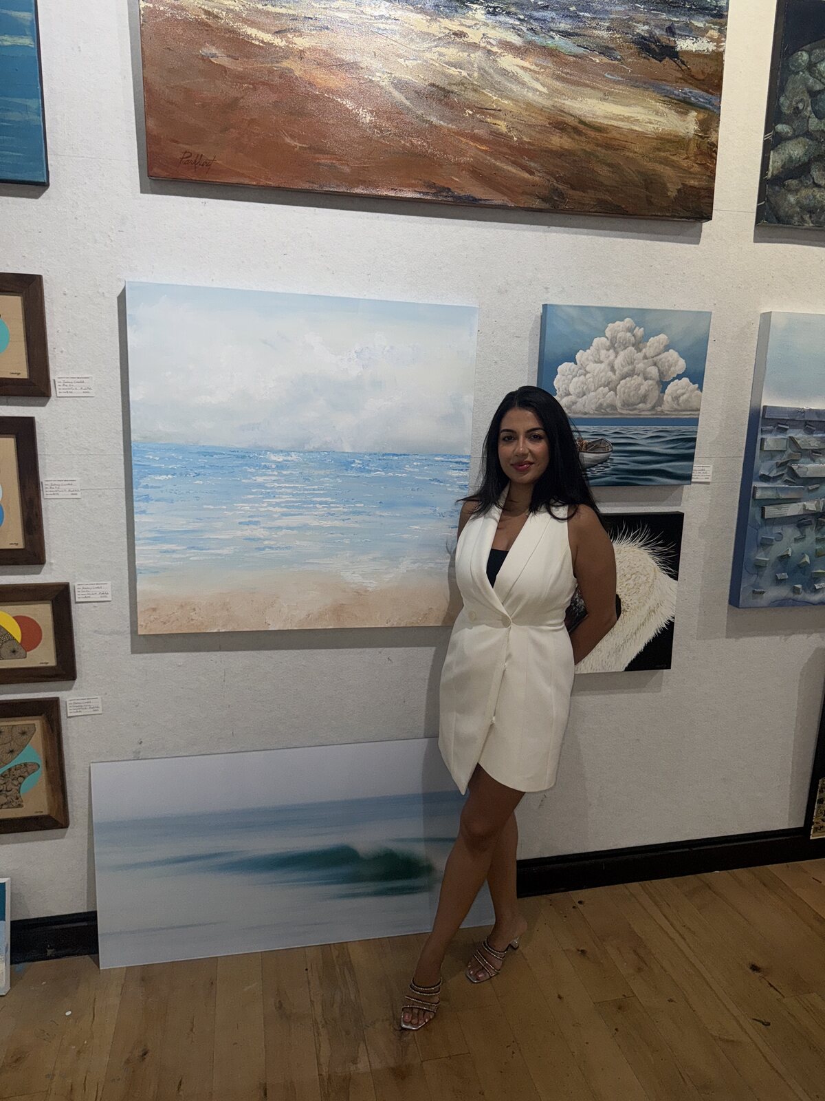 Tara Zarabi standing with her original artwork at a gallery exhibition